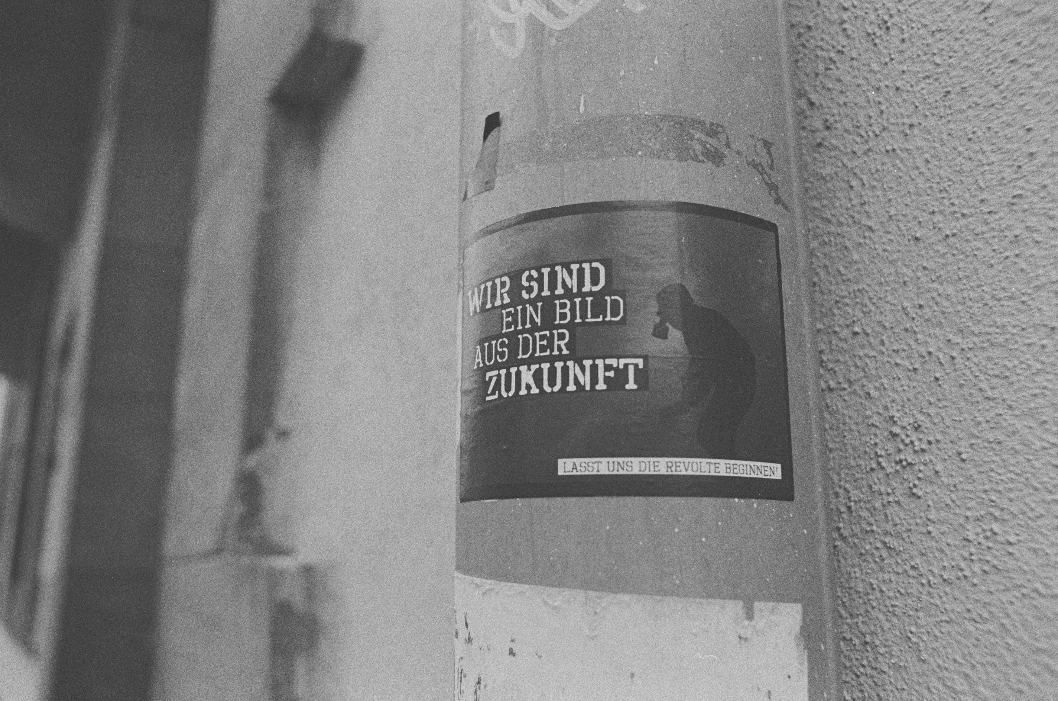 Urban subculture activism sticker: WE ARE A REFLECTION FROM THE FUTURE. LET US BEGIN THE REBELLION. Leica R7 (1994), Elmarit-R 2.8 28mm (1977). Hi-Res analog scan by: www.totallyinfocus.com – Bergger Pancro 400